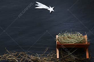 Manger and star of Bethlehem abstracy christmas background nativity scene on black marble