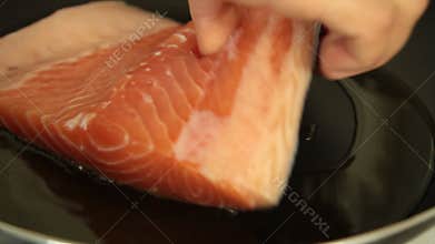 Woman cooking salmon fish at home set