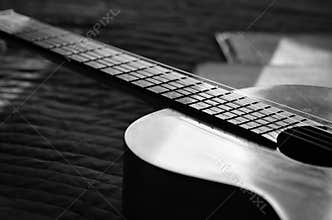 The guitar and music books illuminated by the sun. Black and white
