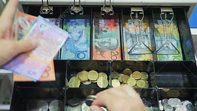 High view of a shop assistant taking australian currency from a cash register