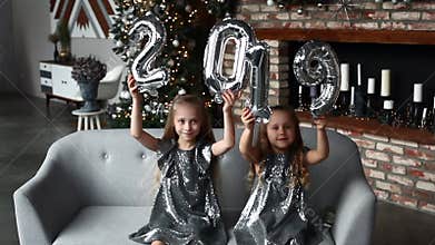Two smile little girls Holding Hands New Year`s Balloons,. Number 2019. Christmas time. New year concept