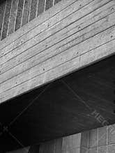 Close up detail of a modern angled textured grey concrete building with shadow