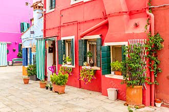Beautiful colorful red small house with plants in Burano island near Venice, Italy