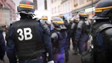 Police officers running to secure the zone in front of the Yellow vests movement protesters