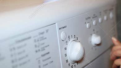 Female hand includes washing machine settings