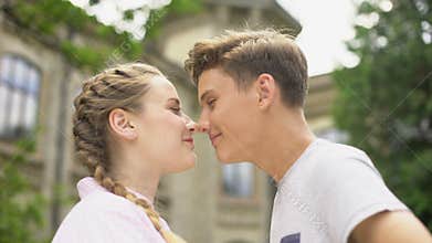 Loving teen couple nuzzling, first love, couple looking at each other, emotions