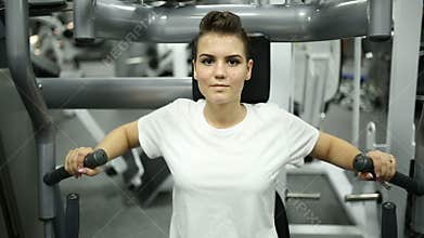 The girl in the gym is engaged on the simulator