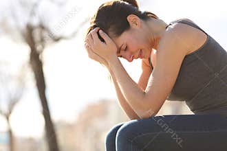 Sad teen crying desperately on a bench