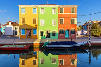 Lovely house facade and colorful walls in Burano, Venice. Burano island canal, colorful houses and boats, Venice landmark, Italy.