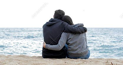 Couple of teens watching the ocean on the beach