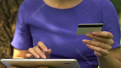Serious woman entering card number on tab, instant money transfer, finance app