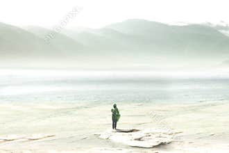 Adventurous traveler crosses alone green mountains