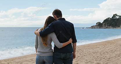 Couple walking holding hands on the beach