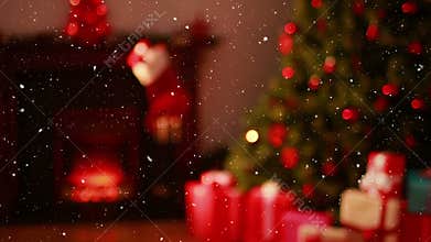 Video composition with falling snow over blurry video of Christmas tree lights and presents in cozy