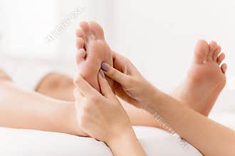 Reflexology. Massager pressing energy flow points on foot