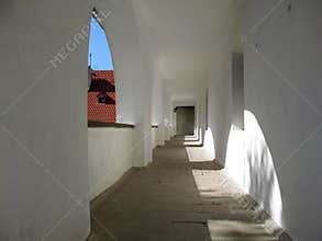 A long corridor with arched windows and white walls at Palanok Castle