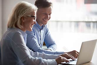 Happy manager and client having conversation at meeting with laptop