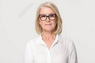 Older businesswoman in glasses looking at camera isolated on background