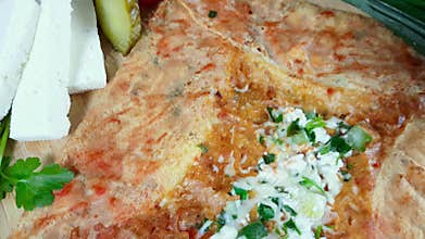 Delicious crepe with cheese served with appetizers and tea on a wooden board