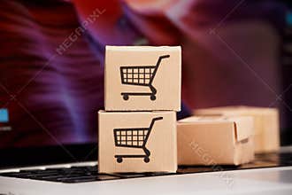 Online shopping . ecommerce and delivery service concept : Paper cartons with a cart or trolley logo on a laptop
