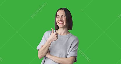 Happy woman giving thumbs up gesture on green background