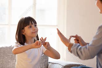 Mother daughter sitting on couch nonverbal communicating with sign language