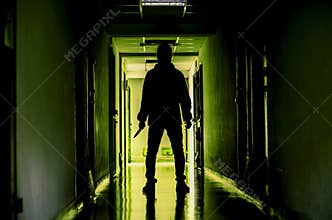 Murder, kill and people concept - Criminal or murderer wearing a mask in silhouette holding knife inside a condo at crime scene