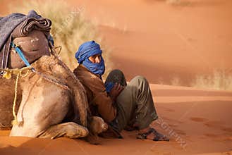 Berber camel guide takes a break morocco