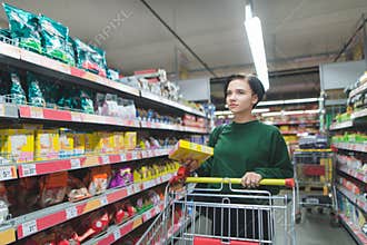 Portrait of a buyer girl with packaging in the middle of a supermarket. positive girl shopping in a supermarket
