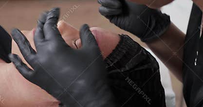 Revealing shot from left to right of a customer during a procedure at a beauty salon