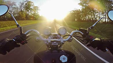 Fast motorcycle riding towards sun in evening. Classic cruiser/chopper forever!