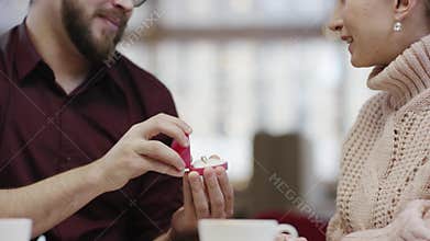 Adult man is making a proposal to his girlfriend and she is happily hugging him