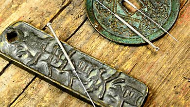Acupuncture needles on antique Chinese coins