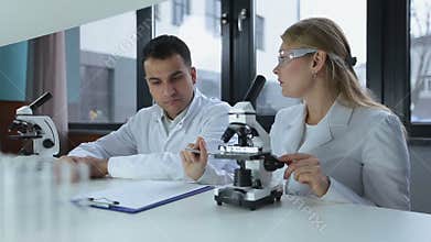 Researchers microscoping in biochemistry lab
