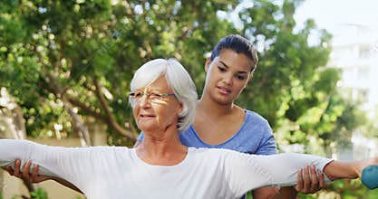 Female trainer assisting senior woman in exercising with dumbbells 4k