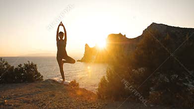 Woman do yoga at sunset