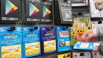 Motion of woman picking cineplex fifty and eighty dollar gift cards
