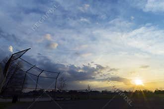 Silhouette of baseball diamond fence at dawn, beautiful sunrise