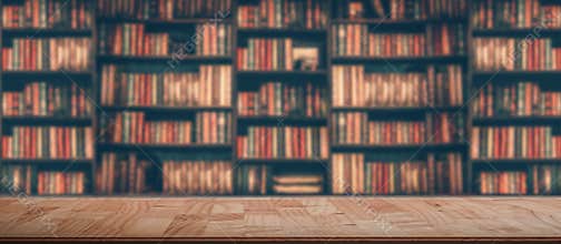 Wooden table in blurred Image Many old books on bookshelf in library