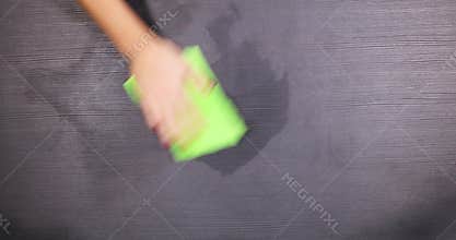 Hand cleaning a table with wet wipe