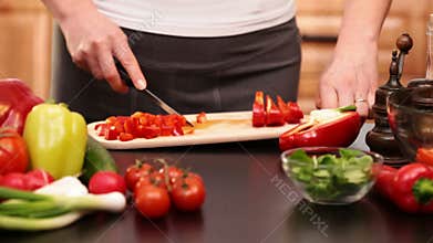 Woman hands chopping red bell pepper slices
