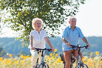 Active elderly couple riding bicycles together in the countrysid