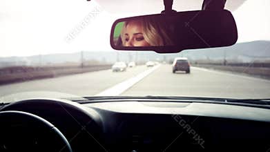 Woman driving car on highway.