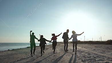 Happy friends running on shoreline