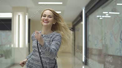 Stylish smiling girl runs for a sale in the shopping center