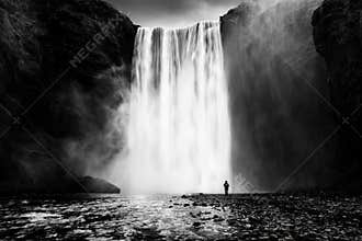 Skogafoss waterfall with a lonely man