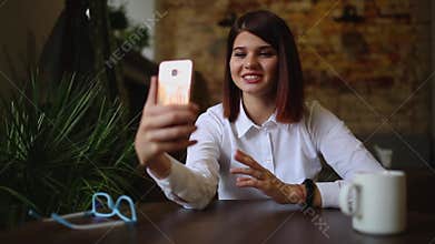 Casual young woman talking on phone having conversation via video chat conference at home office. Businesswoman using