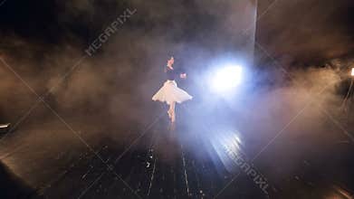 A view from the seats to a stage with a ballerina.