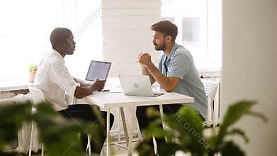 Multiracial partners handshaking making good deal in cozy loft office