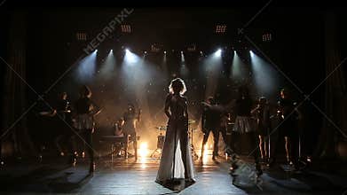 Female singer backlit on smoky stage